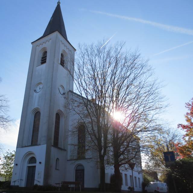 Die evangelische Kirche in Solingen-Widdert, eine weiße Kirche im Sonnenschein
