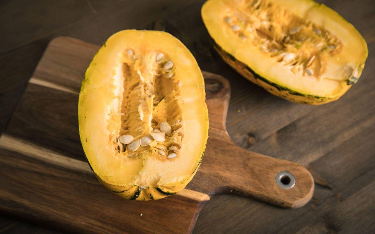 Ein aufgeschnittener Spaghetti-Kürbis liegt auf einem Brett
