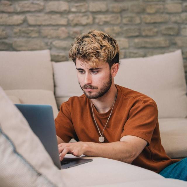 Ein Mann blickt auf ein Laptop