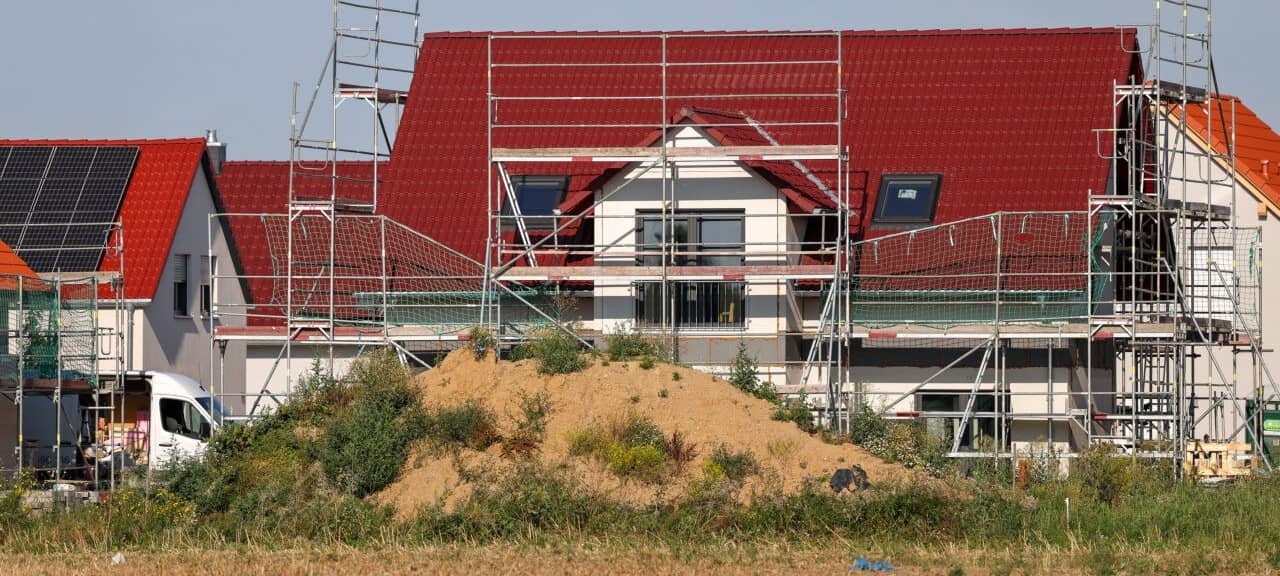 Neue Einfamilienhäuser entstehen an einem Feld am südwestlichen Stadtrand. Die Zahl der Baulandverkäufe ist Immobilienexperten zu Folge seit 2021 fast um die Hälfte zurückgegangen. Gestiegene Zinsen, hohe Baukosten und knappes Bauland haben den Traum vom Eigenheim stark verteuert.