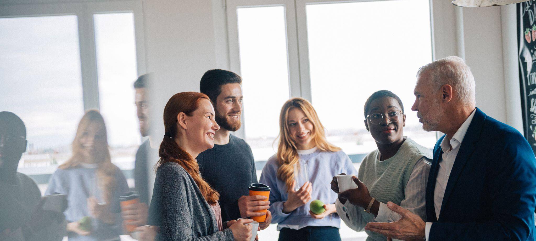 Eine Gruppe Kollegen macht Pause in der Büroküche