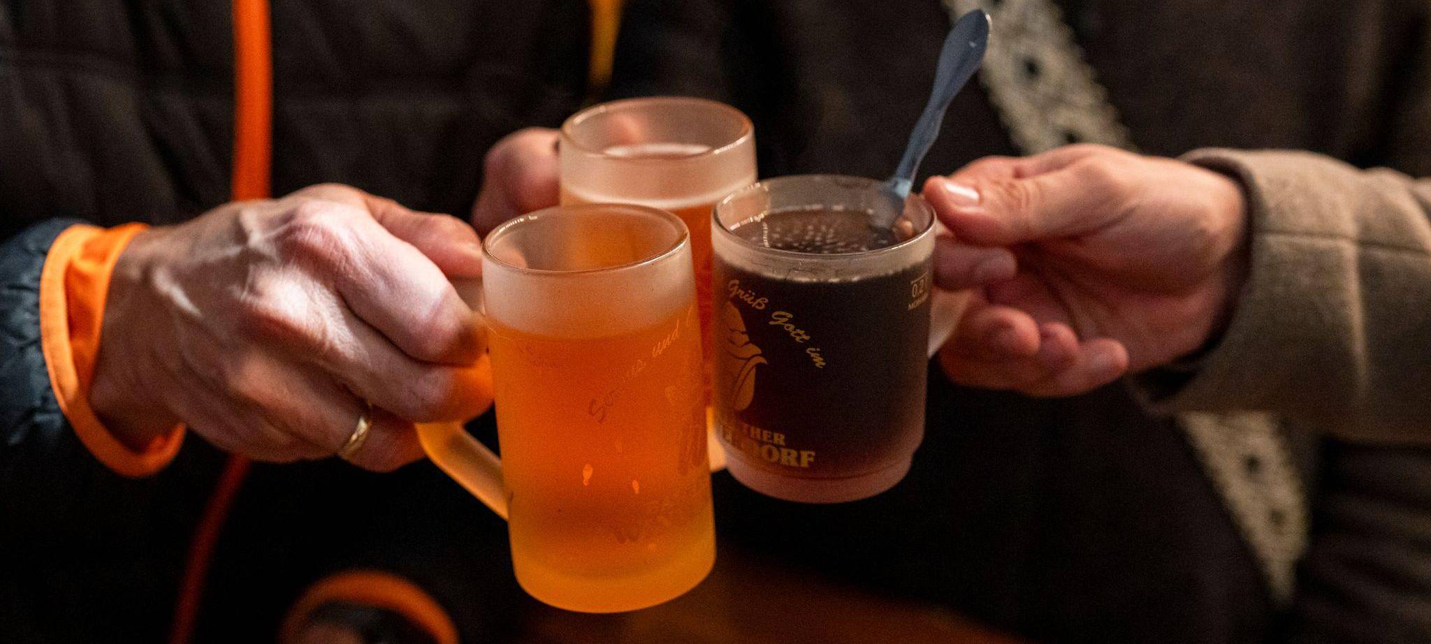 Drei Personen stoßen mit Glühwein an