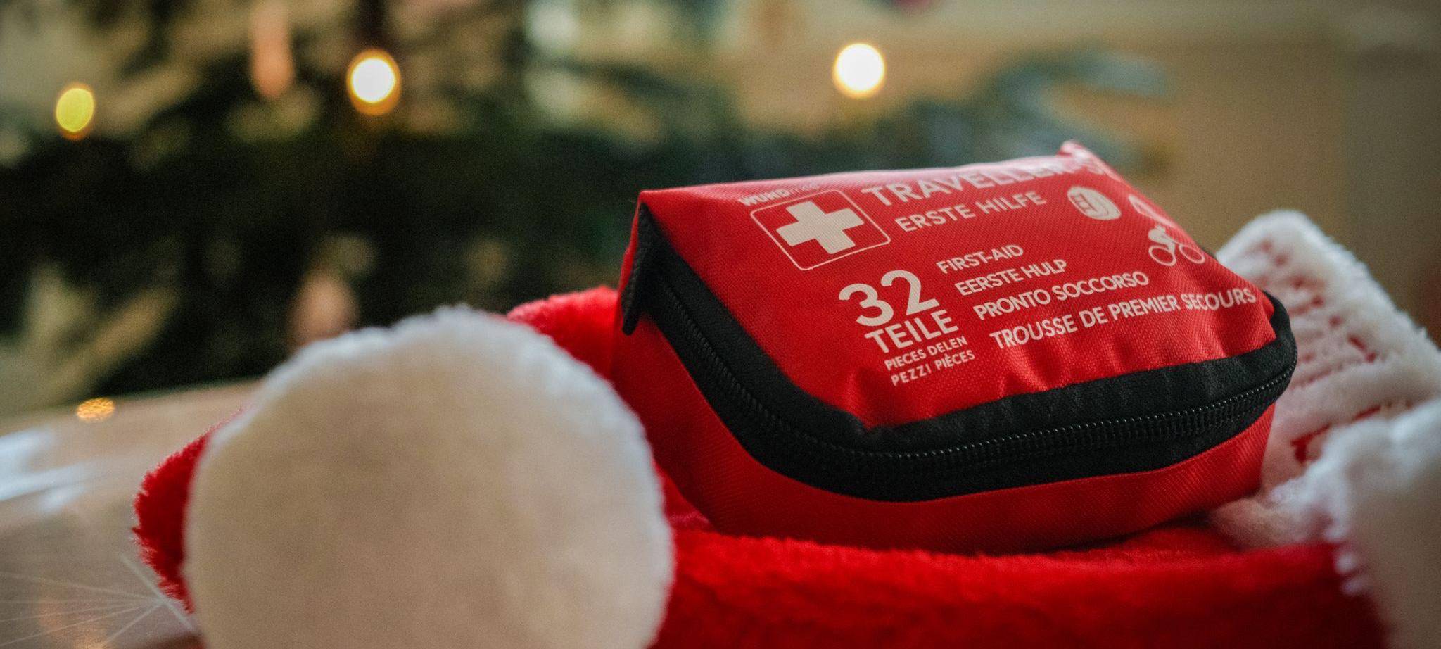 Ein Erste-Hilfe-Set liegt auf einer Weihnachtsmütze