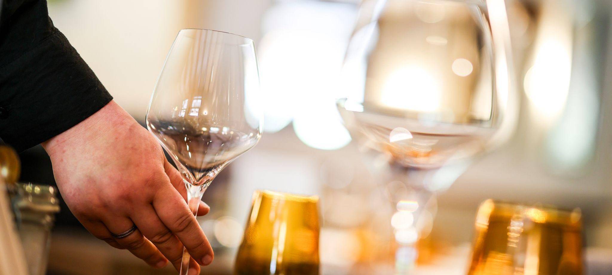 Eine Mitarbeiterin stellt beim Eindecken ein Glas auf