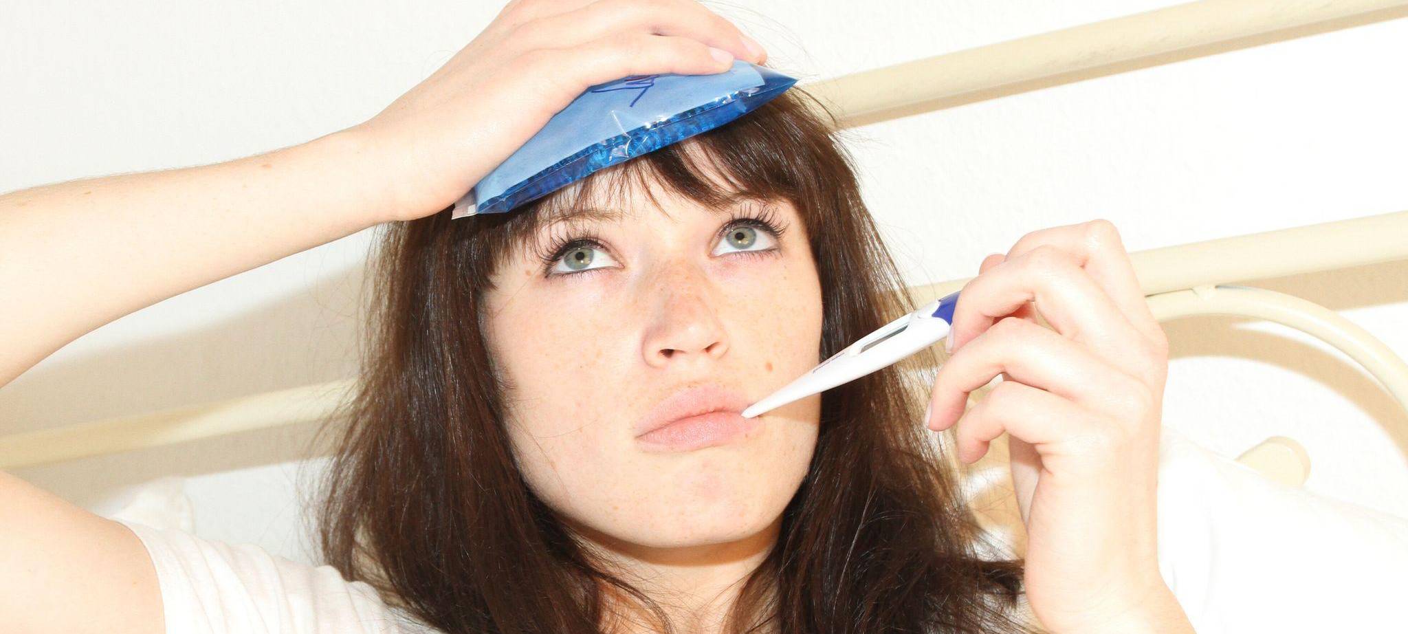 Frau liegt krank im Bett