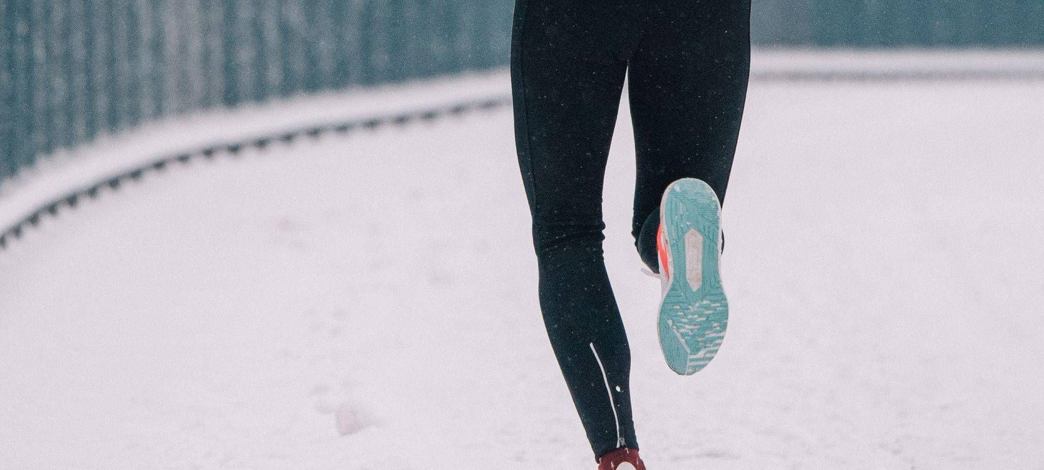 Eine Joggerin läuft durch Schnee