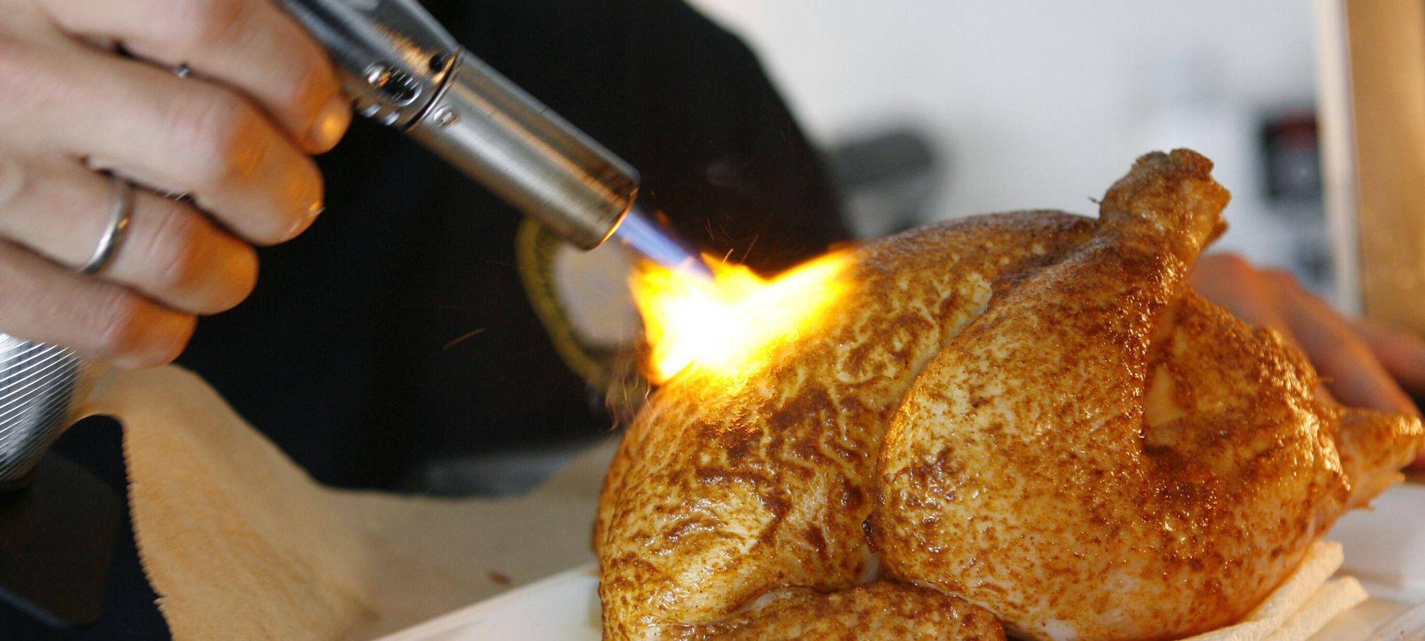Ein Hähnchen mit einem Bunsenbrenner bräunen