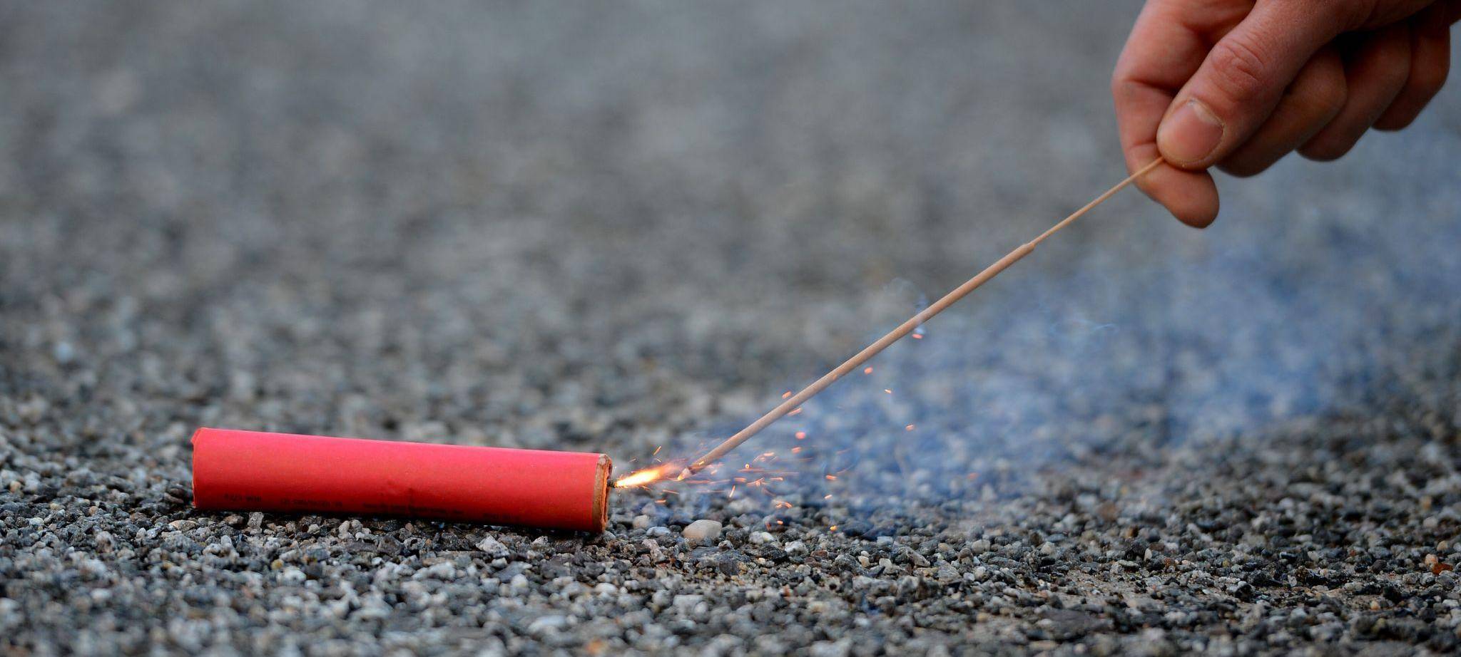 Pyrotechniker der Feuerwehr zündet einen Böller an
