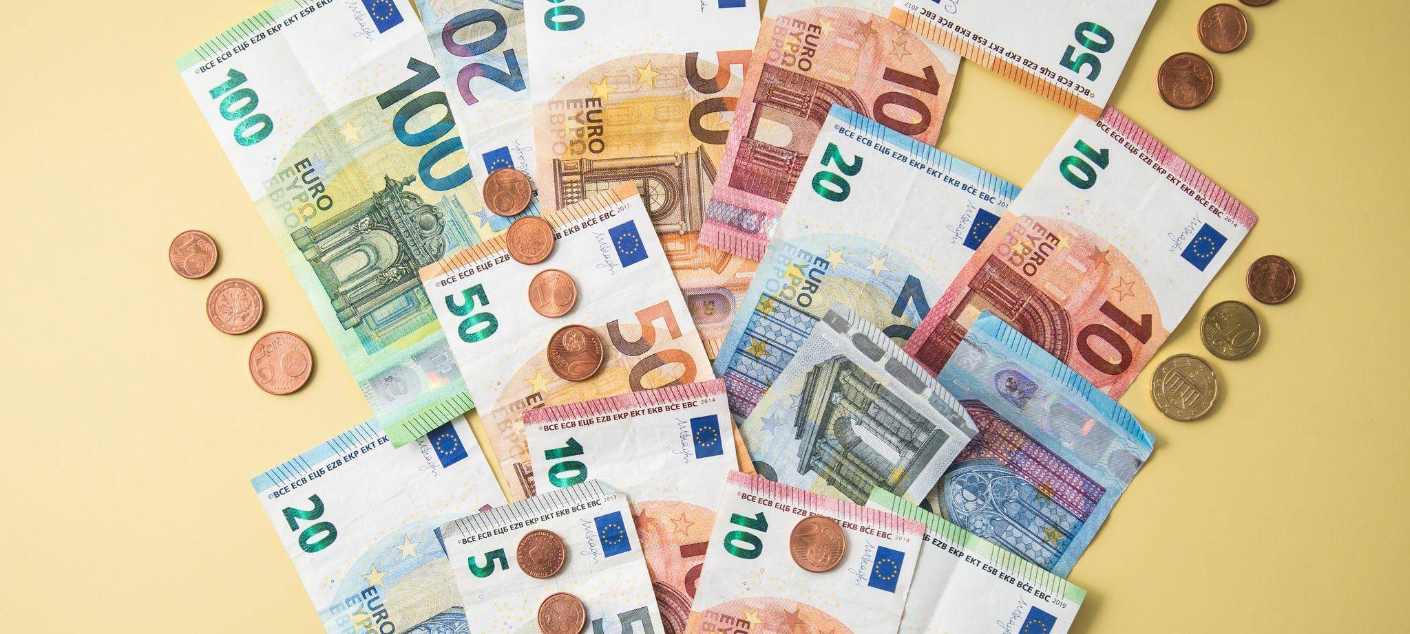 Geldscheine und Münzen fliegen aus einer Geldbörse