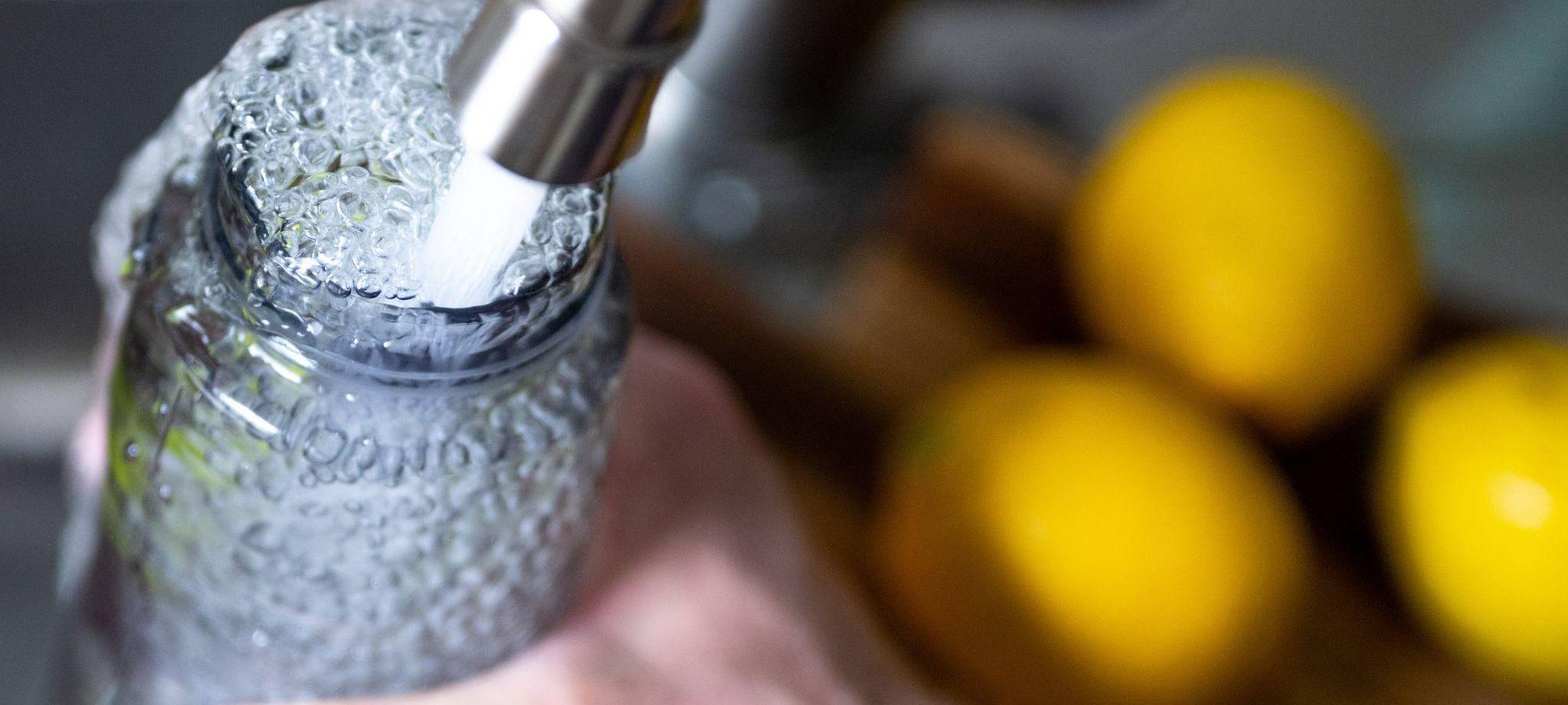 Eine person füllt ihre Trinkflasche auf