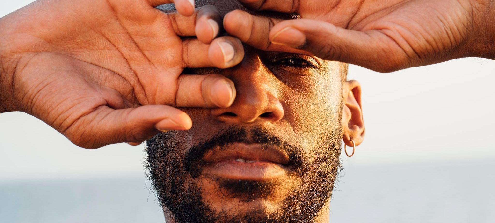 Ein Mann mittleren Alters hält die Hände vors Gesicht