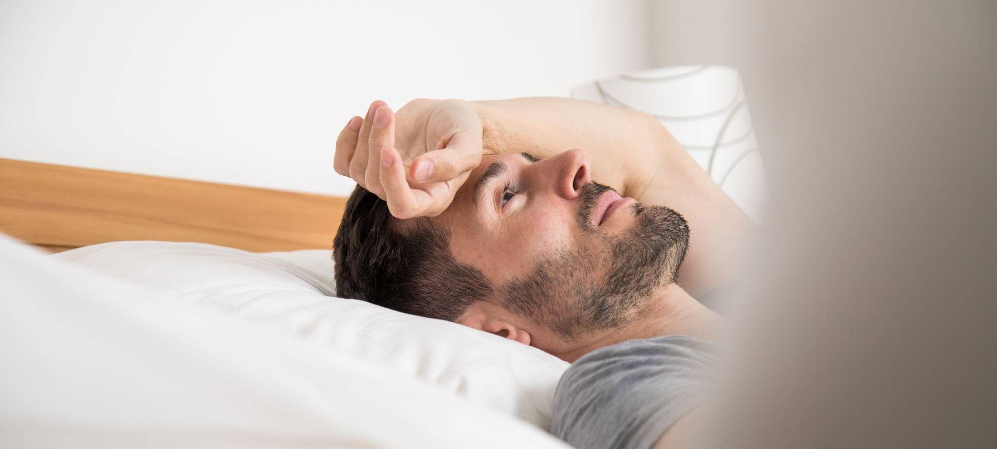 Ein junger Mann liegt im Bett