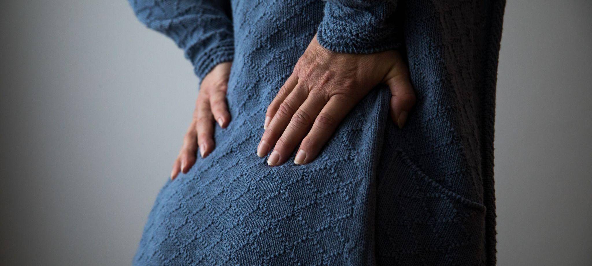 Frau hält sich den schmerzenden Rücken