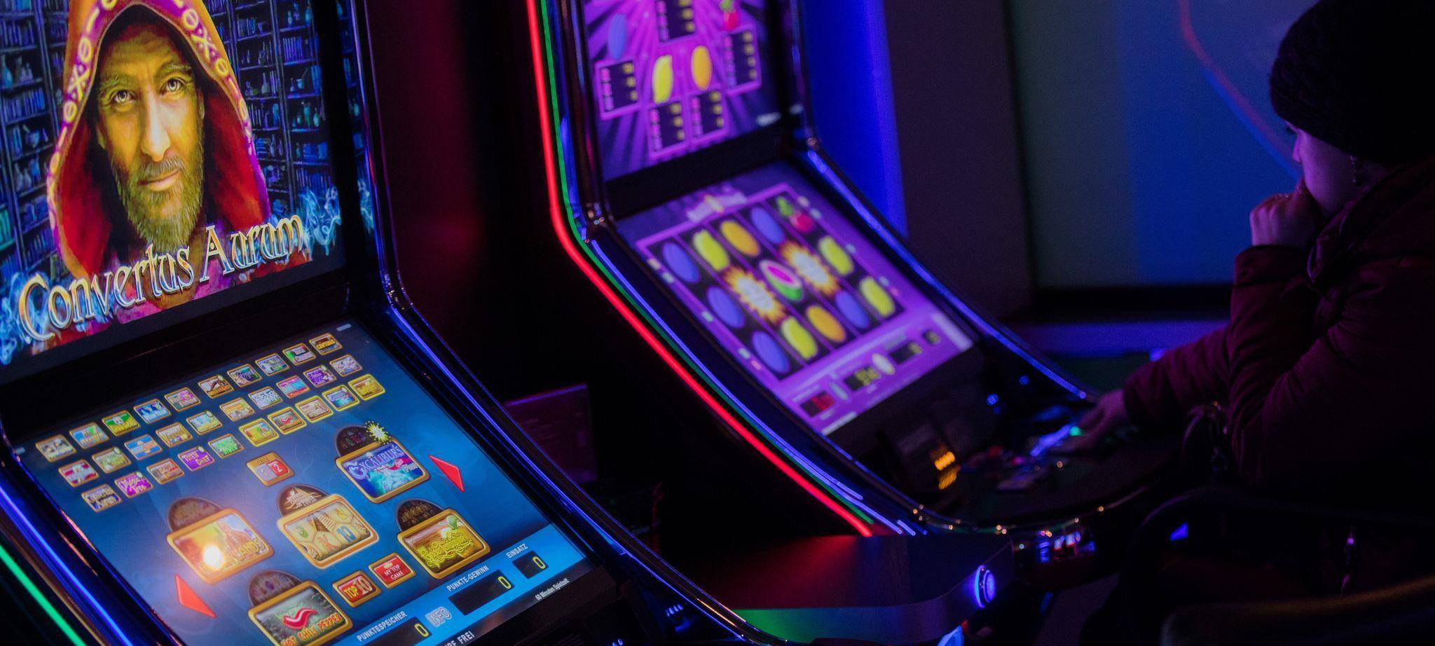 Eine Person sitzt an einem Spielautomaten