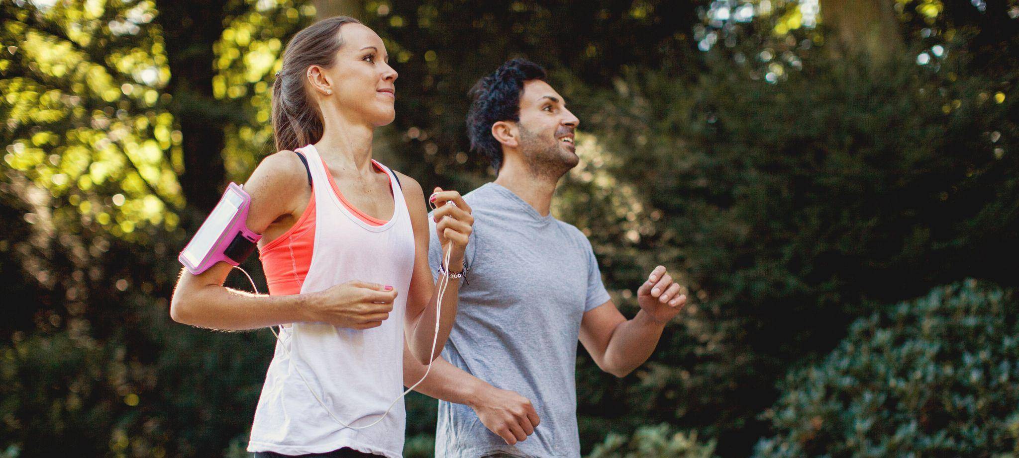 Eine Frau und ein Mann joggen im Park